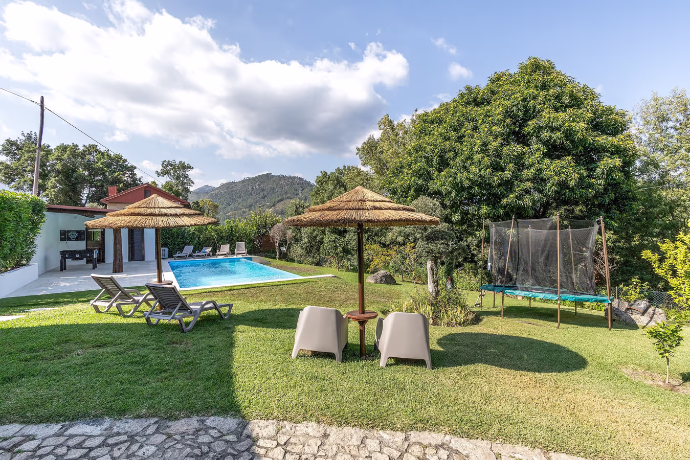Jardim, piscina e sombra de colmo